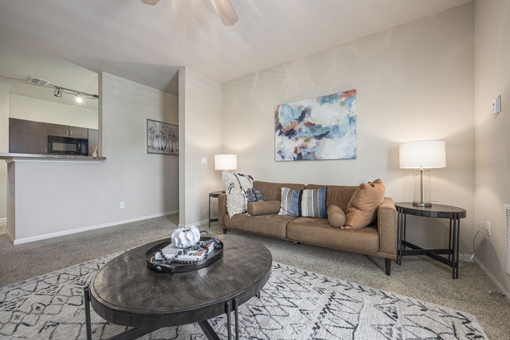 A living room with a couch, a coffee table, and a painting on the wall.