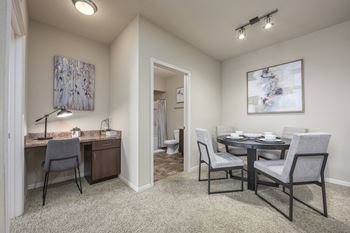 A room with a desk and a dining table.