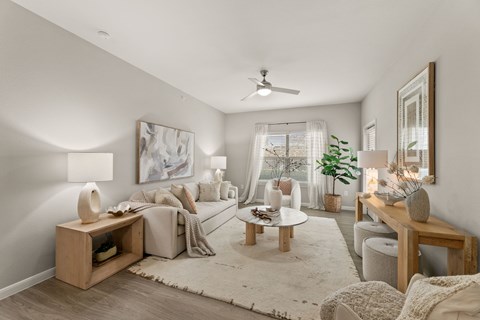 A living room with a white sofa, a wooden coffee table, and a large painting on the wall.