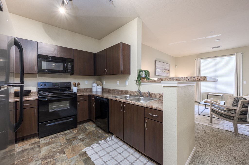 A kitchen with brown cabinets and a black stove top oven.