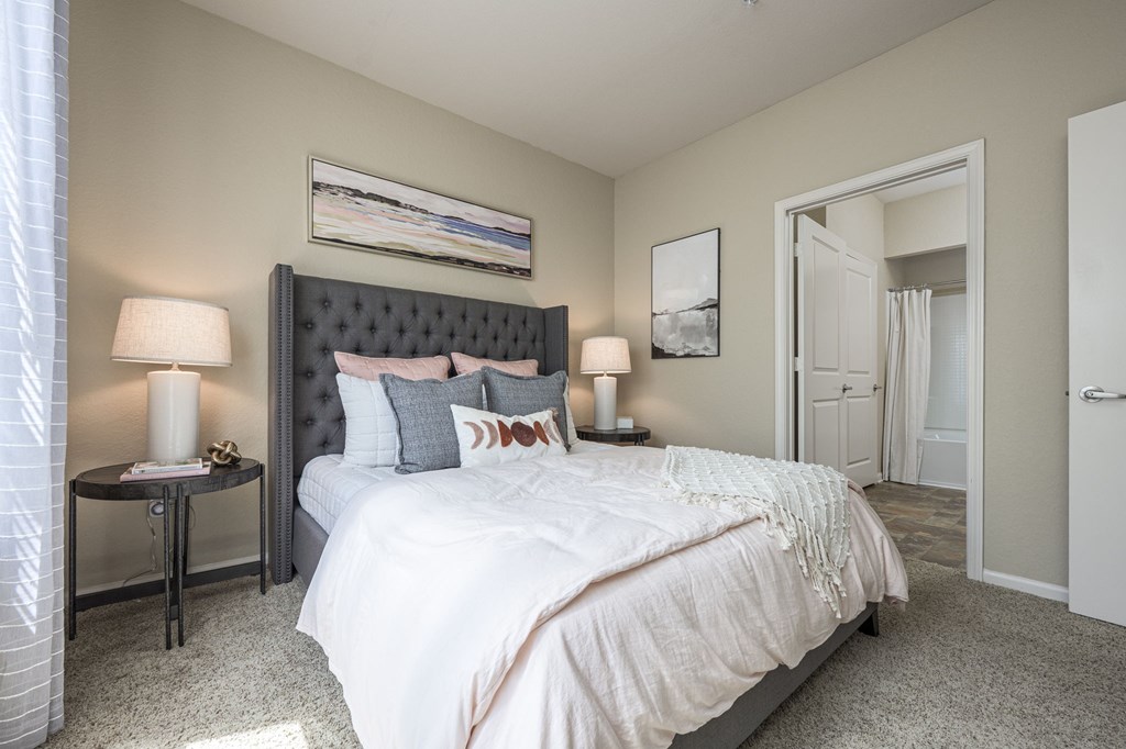 A bedroom with a large bed and a painting on the wall.