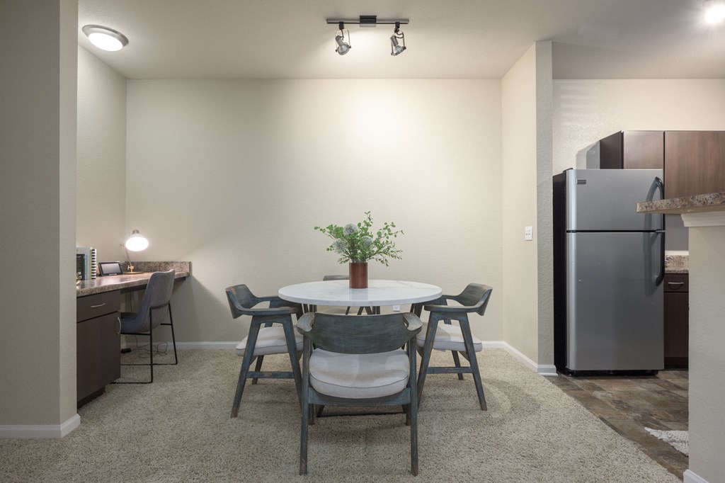 A kitchen with a table and chairs.