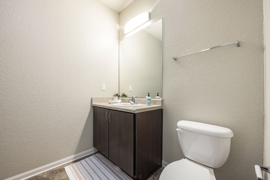 A white toilet sits next to a sink in a small bathroom.
