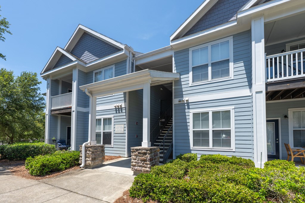 A blue two-story house with a white porch.at Spring Creek Apartments, Crestview