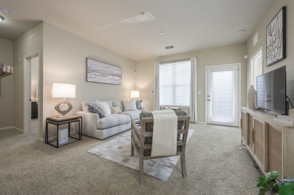 A living room with a couch, a chair, and a television.