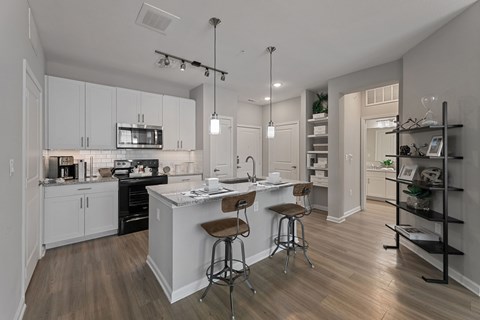 A modern kitchen with white cabinets and a wooden island.