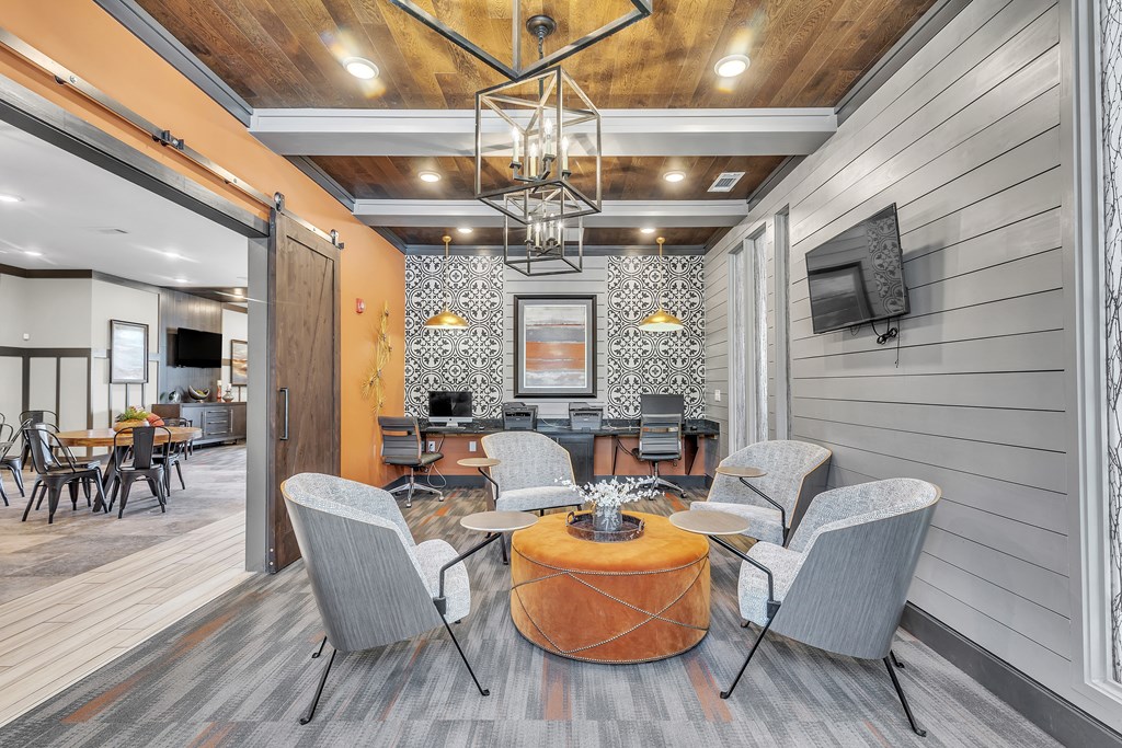 Modern living room with a wooden ceiling and grey chairs at Sterling Creek at Richmond Hill, Richmond Hill, GA, Georgia 