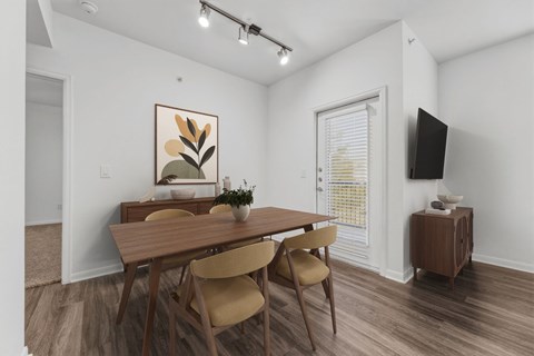 A dining room with a wooden table and chairs.