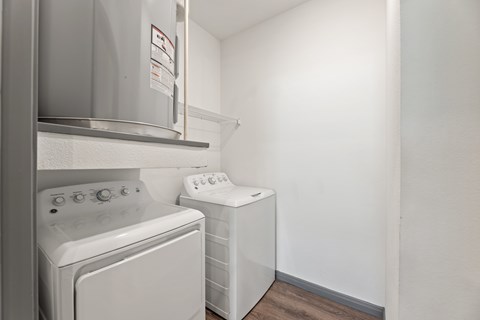 A white washing machine and dryer in a small laundry room at The Preserve at Preston Trails Apartments, Cedar Hill, TX, 75104