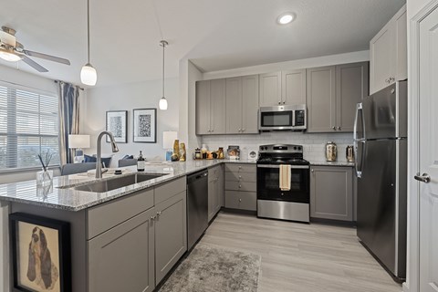 A modern kitchen with a refrigerator, sink, and stove.