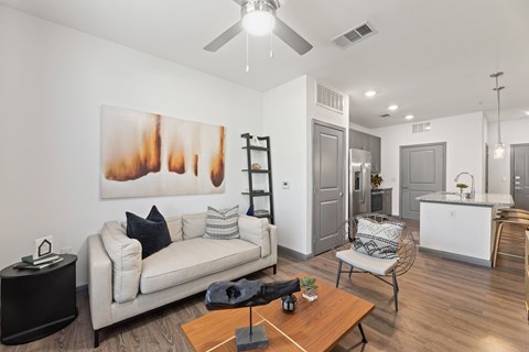 A living room with a white couch and a painting on the wall at The Preserve at Preston Trails Apartments, Texas