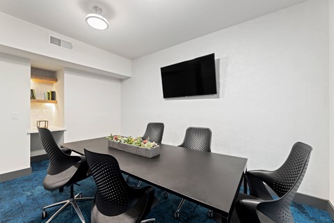 A conference room with a long table and chairs at The Preserve at Preston Trails Apartments, Texas, 75104