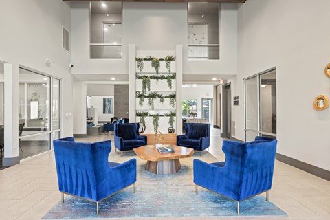 A living room with blue chairs and a rug at The Preserve at Preston Trails Apartments, Cedar Hill, TX, 75104