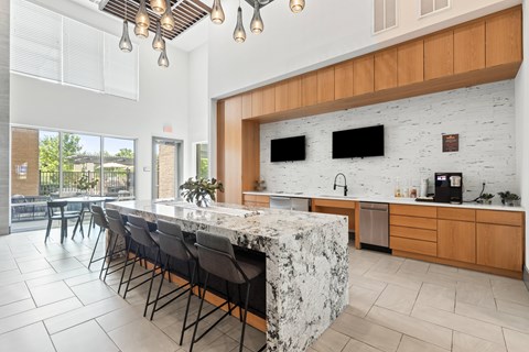 A kitchen with a marble island and wooden cabinets at The Preserve at Preston Trails Apartments, Cedar Hill, Texas
