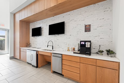 A kitchen with a white brick wall and wooden cabinets at The Preserve at Preston Trails Apartments, Cedar Hill 75104