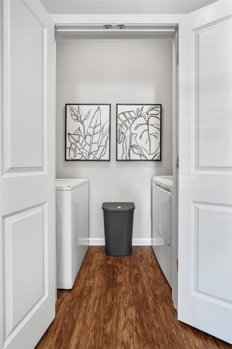 A hallway with a trash can and two framed pictures on the wall.at Cypress River, Ladson, 29456