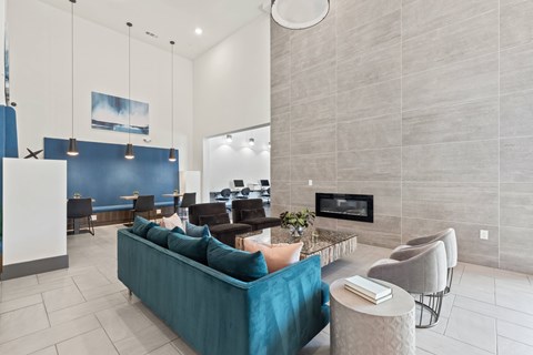 A living room with a blue couch and a fireplace at The Preserve at Preston Trails Apartments, Cedar Hill, TX