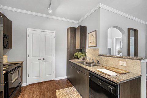 A kitchen with a black oven and a white door.