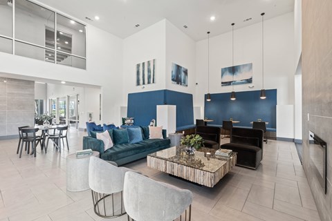 A modern living room with a blue accent wall and a coffee table in the center at The Preserve at Preston Trails Apartments, Cedar Hill, TX, 75104