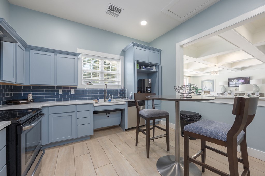 A kitchen with a blue cabinetry and wooden flooring.at Spring Creek Apartments, Crestview