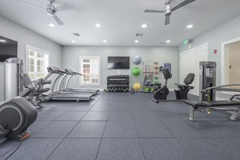 A spacious gym with treadmills, elliptical machines, and other exercise equipment.