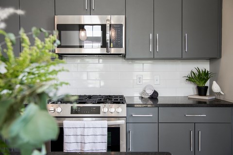 A modern kitchen with a stove top oven and a microwave above it.