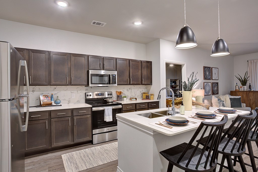 Modern kitchen with dark brown cabinets and stainless steel appliances at Edge and Stone, San Antonio, TX, 78260