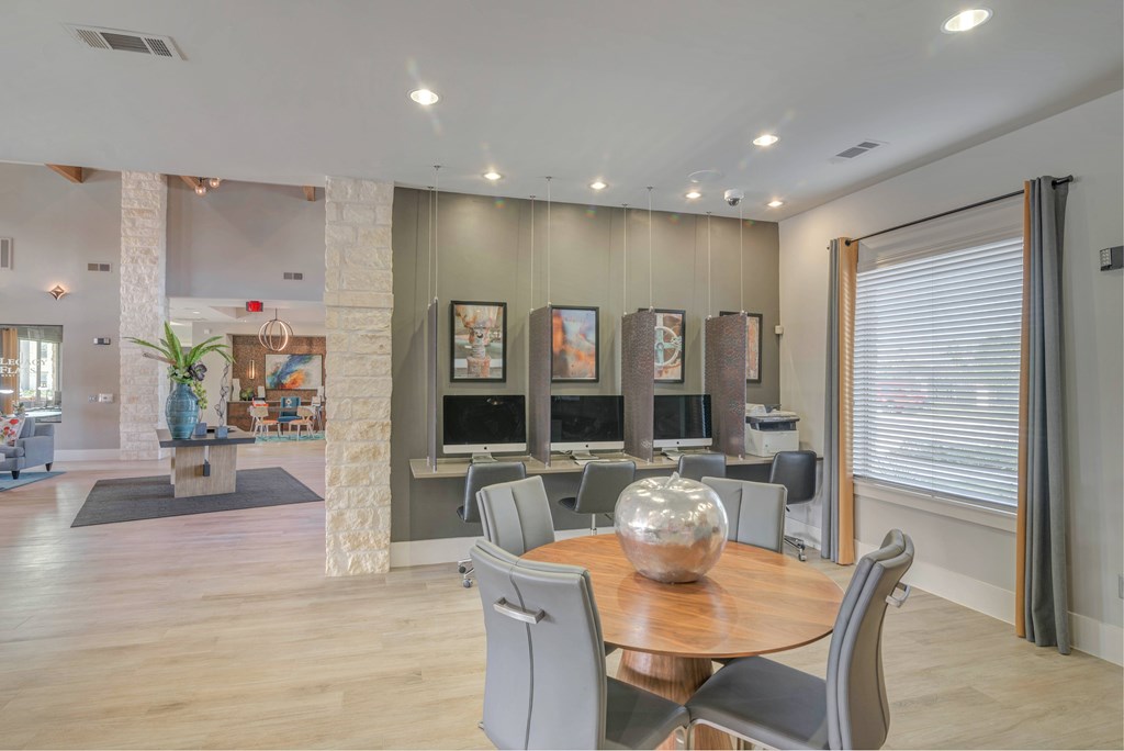 A modern dining room with a wooden table and grey chairs.