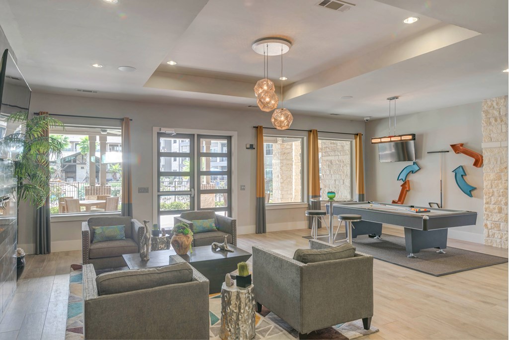 A living room with a pool table and a view of the backyard.
