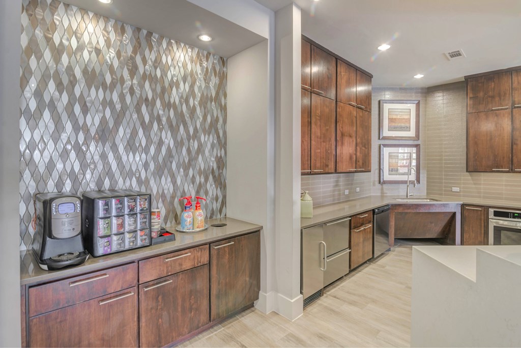 A kitchen with wooden cabinets and a diamond patterned backsplash.