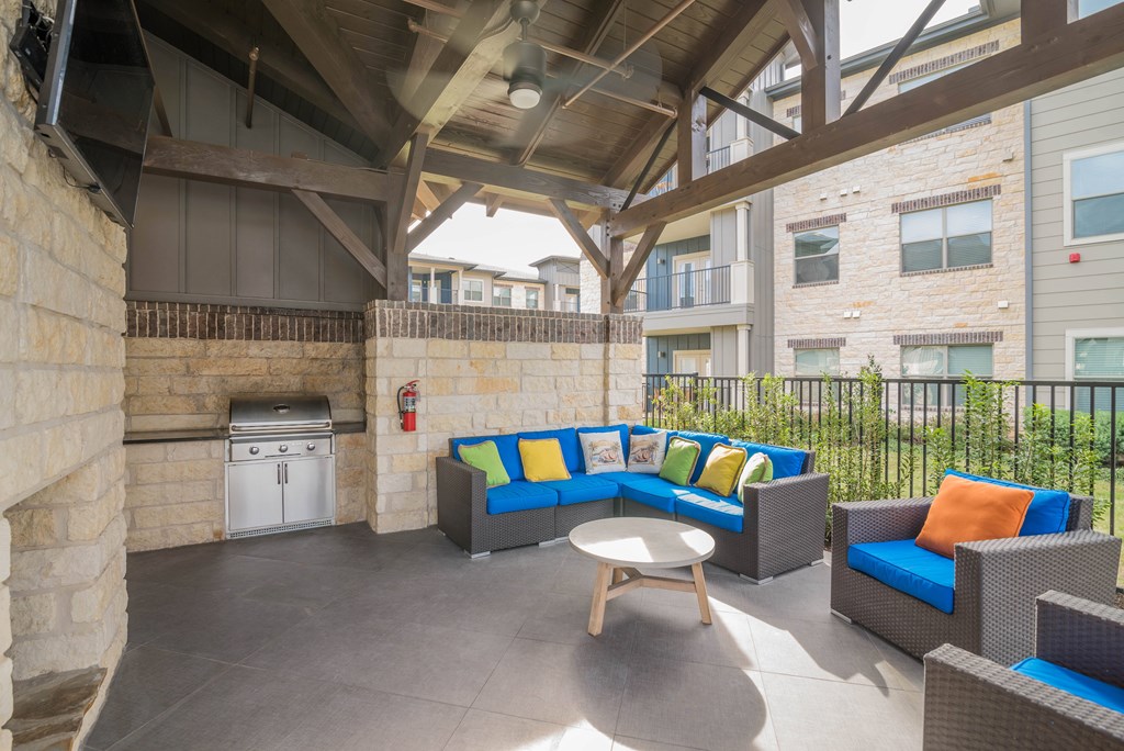 A patio with a couch, chairs, and a table.