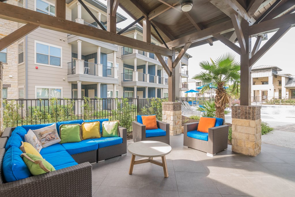 A patio with a blue couch and a wooden table.
