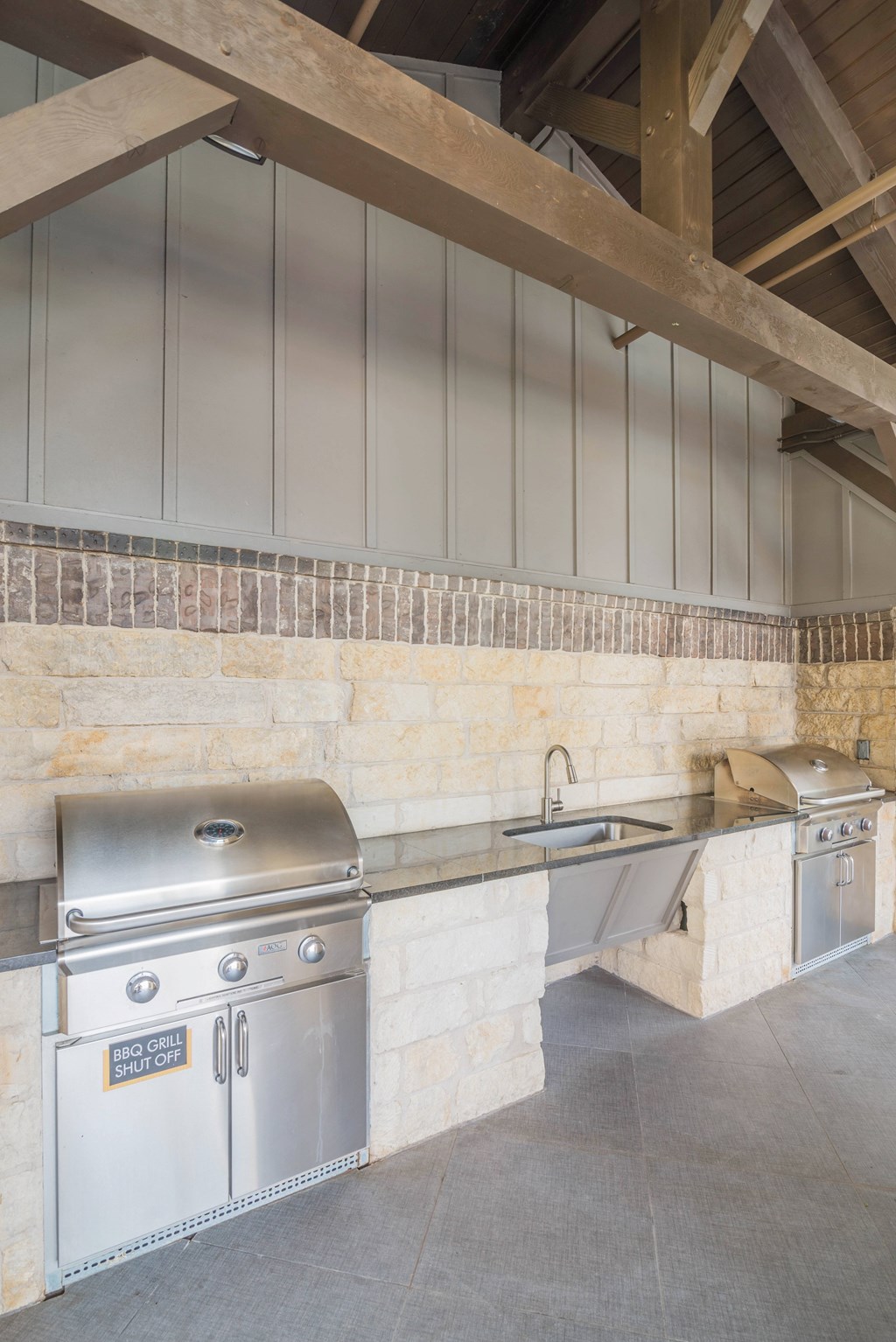 A BBQ grill is on the left and a sink is on the right.