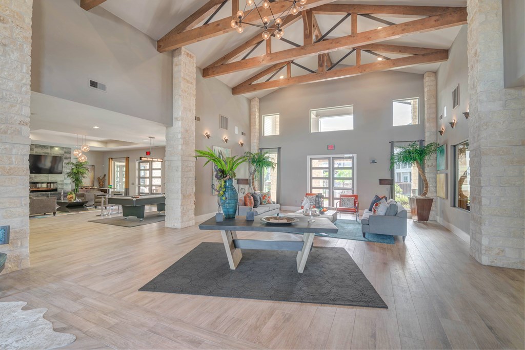 A spacious living room with wooden beams and a central coffee table.