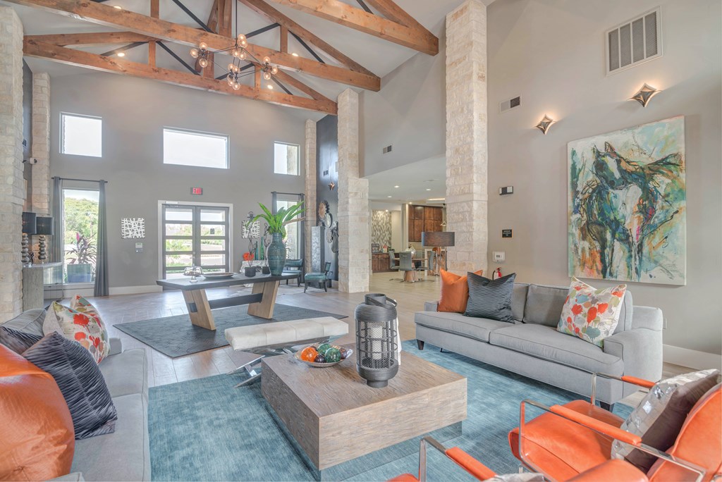 A living room with a grey couch and orange chairs.
