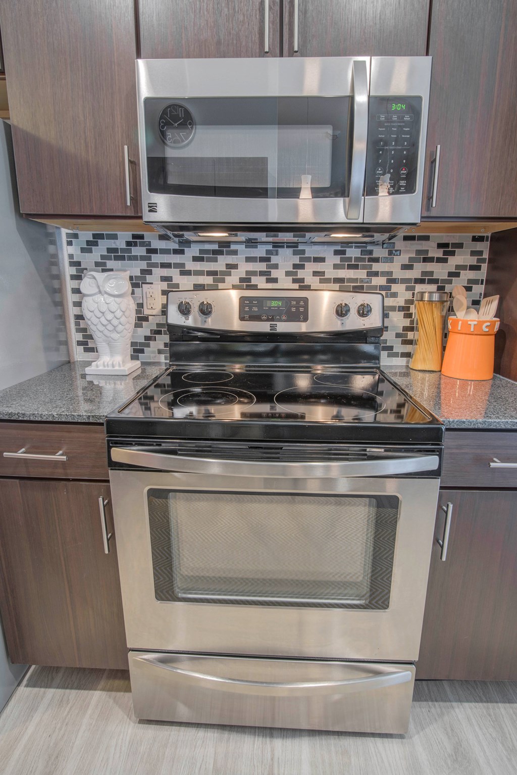 A modern kitchen with a stainless steel oven and microwave above it.