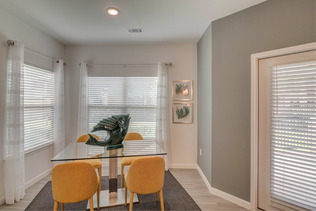 A dining room with a glass table and chairs.