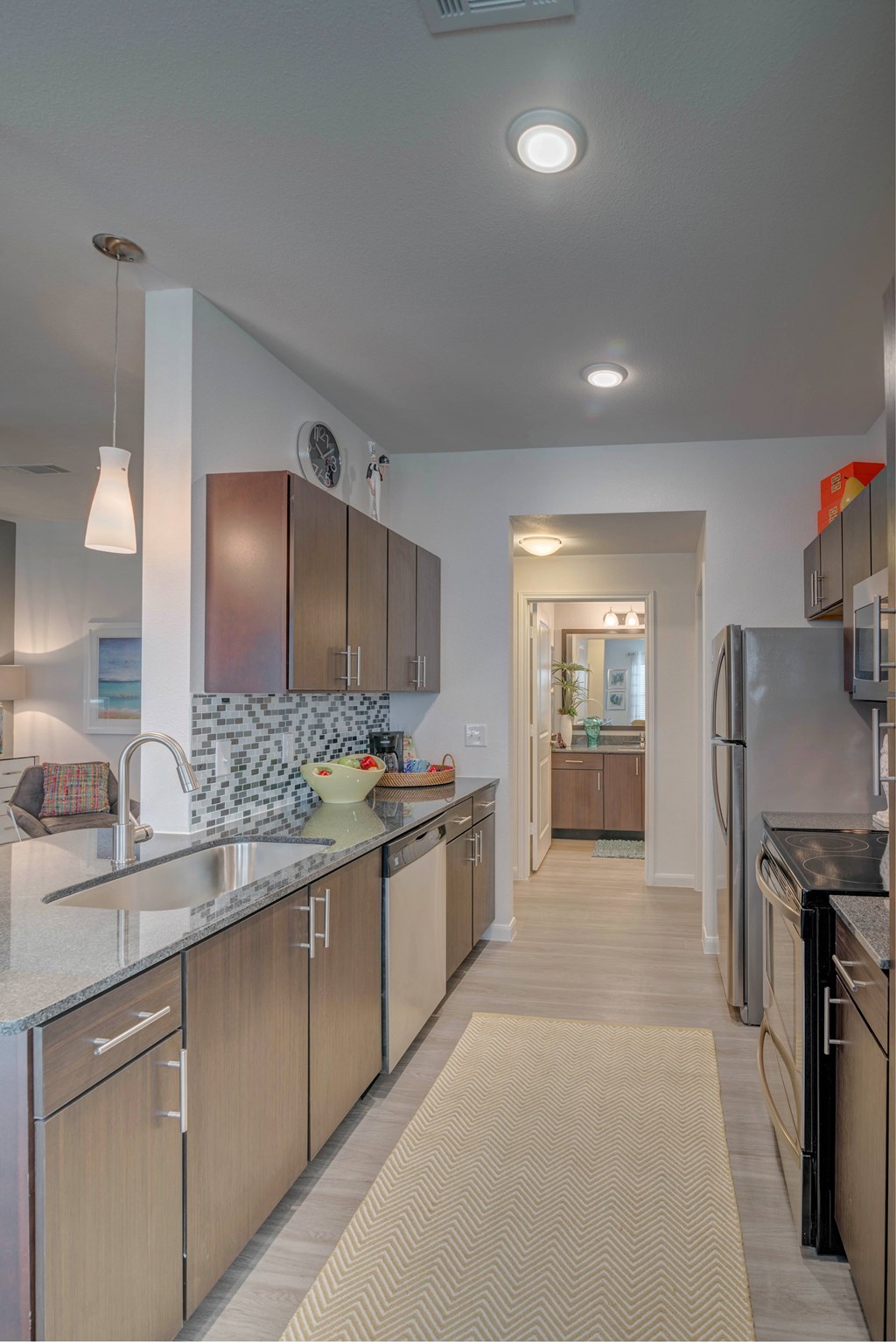 A kitchen with a refrigerator on the right and a sink on the left.