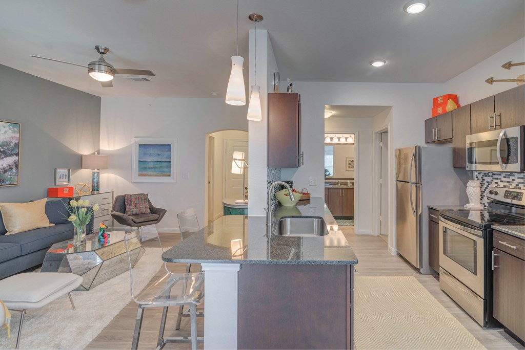 A modern kitchen with a dining area and a living room.