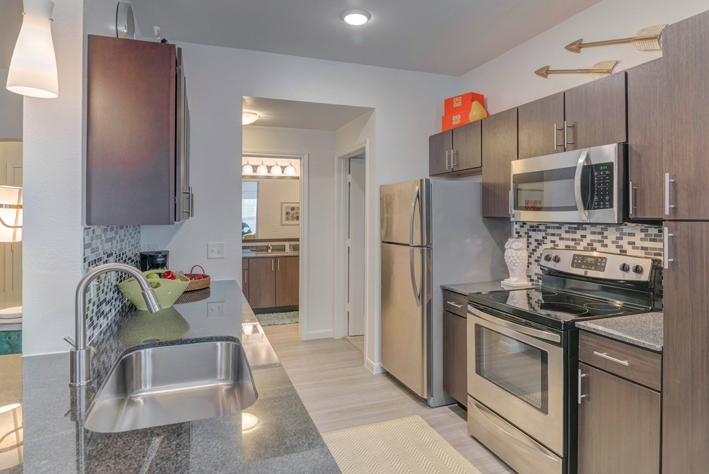 A modern kitchen with stainless steel appliances and wooden cabinets.