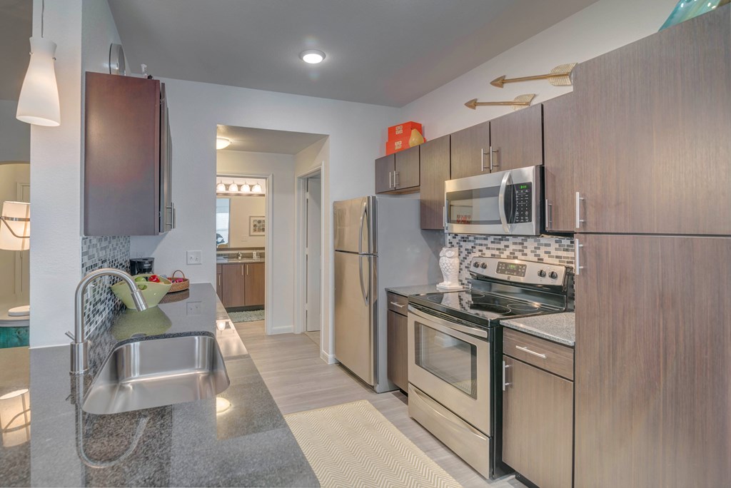 A kitchen with a stove top oven and a microwave above it.