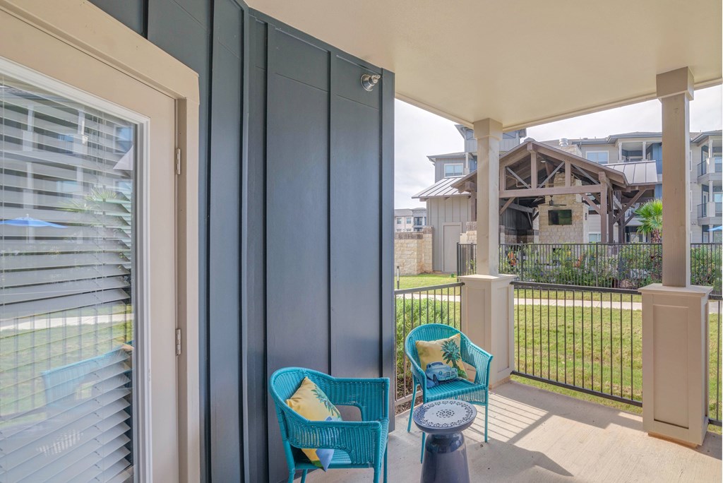 A balcony with a blue chair and a table.