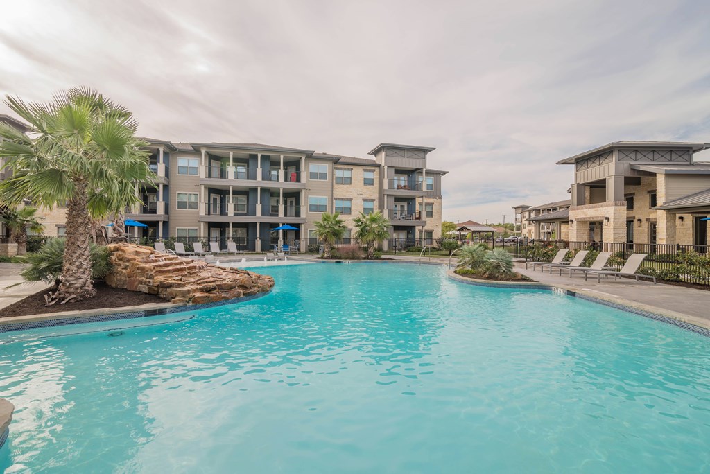 A swimming pool in front of apartment buildings.