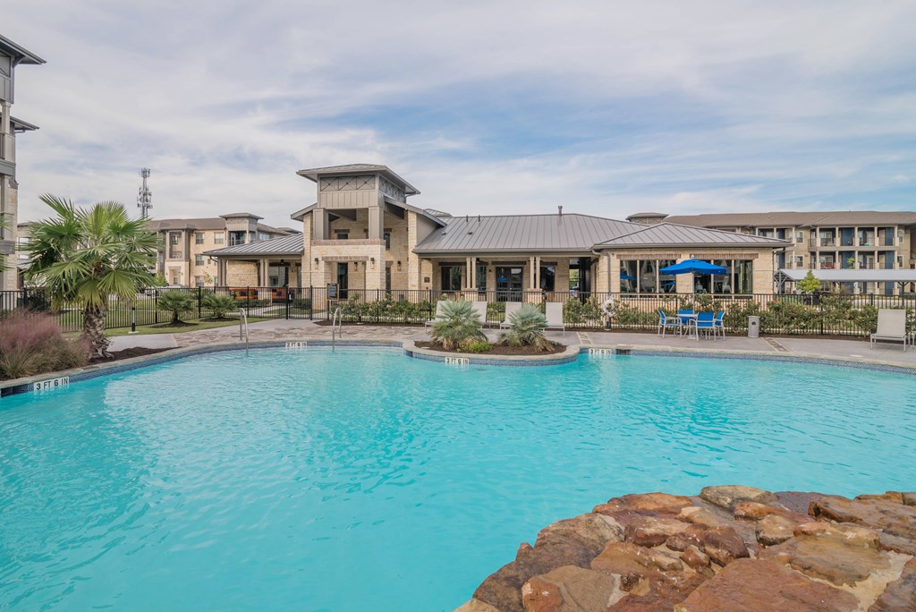A large swimming pool in front of a resort-style building.