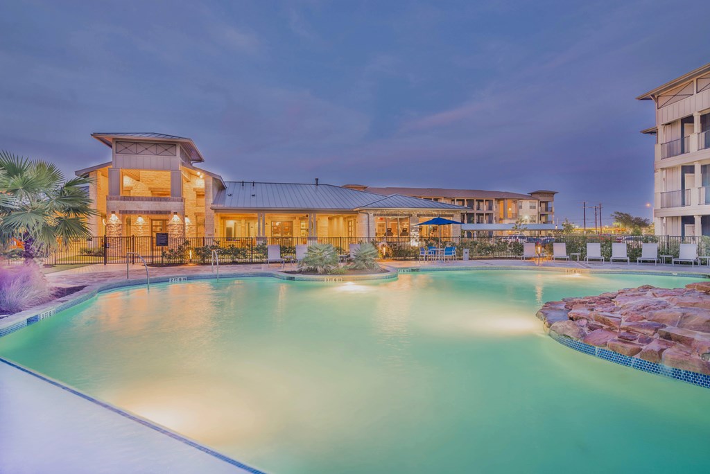 A large building with a pool in front of it.