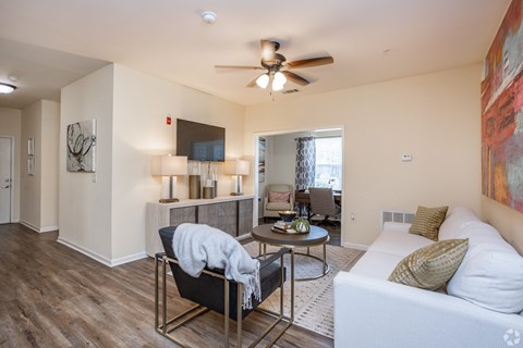 A living room with a white couch and a black chair.