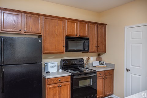 A kitchen with wooden cabinets and black appliances.