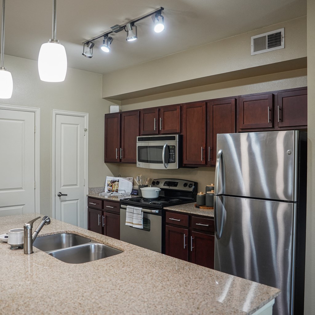 a kitchen with stainless steel appliances and granite counter tops at Platinum Castle Hills, Lewisville, TX, 75056