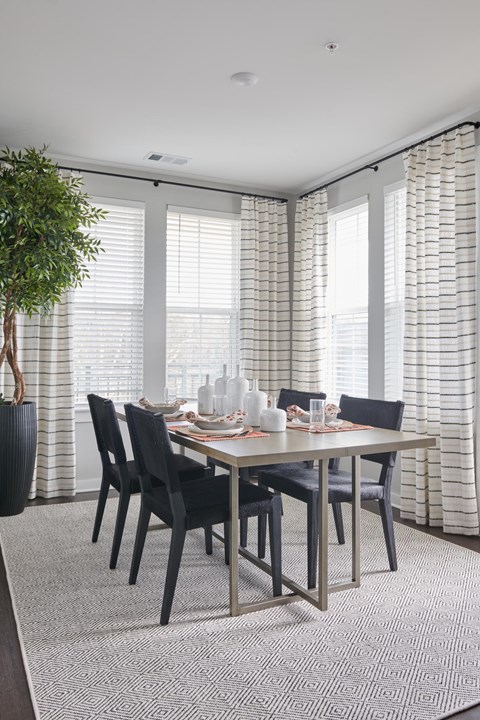 A dining room with a table set for six.