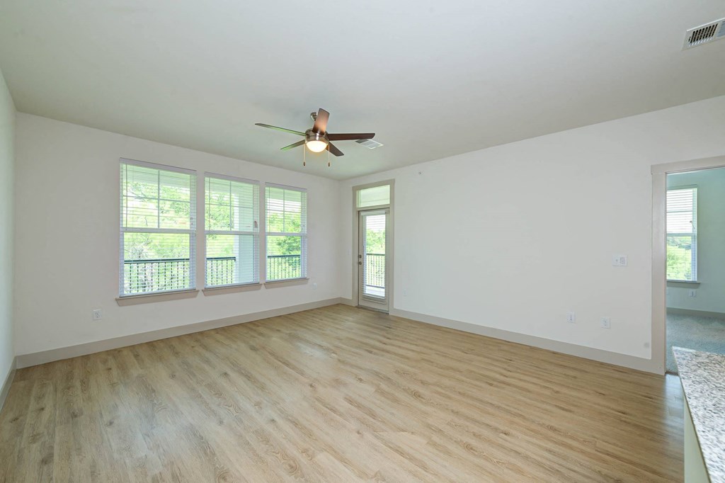 an empty living room with a ceiling fan and windows at Legacy at Cibolo, Boerne
